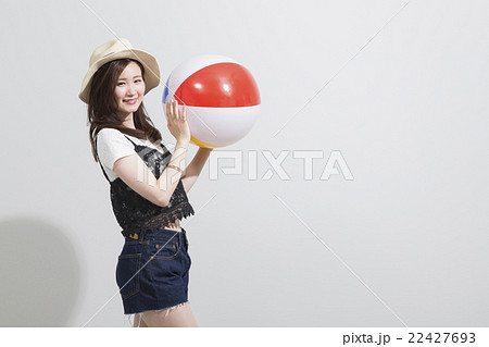 ビーチボールを持つ女性の写真素材
