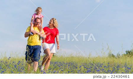 Family having walk on meadow with flowers 22430461