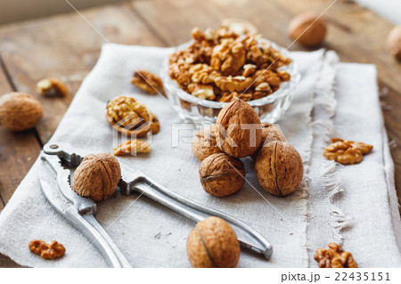 Glass bowl with walnuts on rustic homespun napkin. 22435151