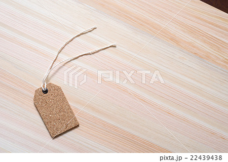ヒノキのテーブルに置かれたタグ ラベル 値札 背景素材 木目斜めの写真素材
