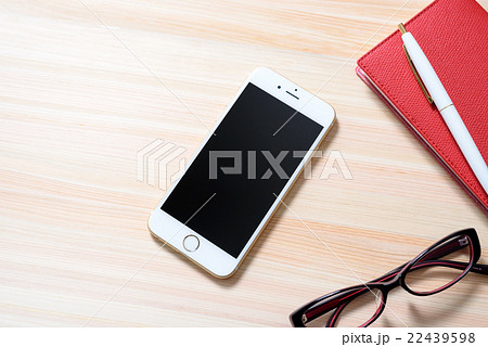 ヒノキのテーブルに置かれたタグと手帳とスマホ ビジネス スケジュール メモ 背景素材 の写真素材