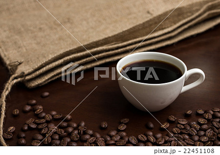 コーヒーを囲むようにコーヒー豆と麻袋 横から コーヒーを囲むようにコーヒー豆と麻袋 横から 22451108
