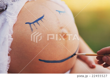 Pregnant woman belly closeup with smile funny face 22455527