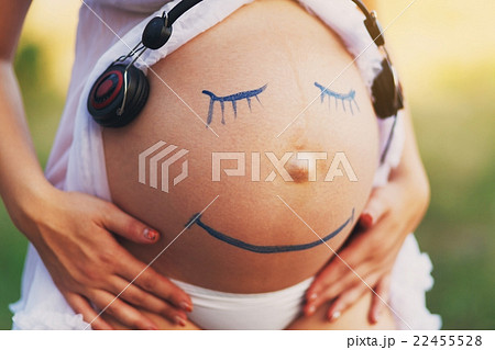 Pregnant woman belly closeup with smile funny face 22455528