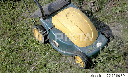 Mowing grass in the garden with electrical machine Mowing grass in the garden with electrical machine 22456029