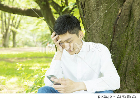 スマホ 男性 考える 悩む 困る ポートレート 外 公園 緑 カジュアル スマホ 男性 考える 悩む 困る ポートレート 外 公園 緑 カジュアル 22458825