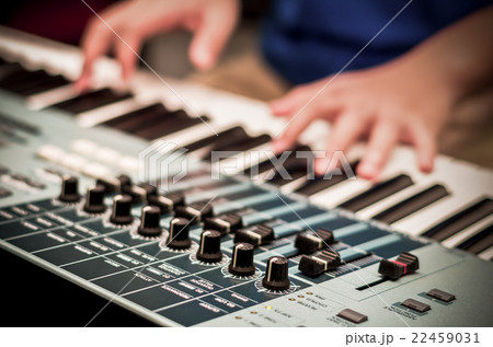 closeup audio mixer on hands playing the keyboard background,vintage color tone closeup audio mixer on hands playing the keyboard background,vintage color tone 22459031