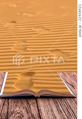 Open book image of Footprints on the sand waves as background 22459421