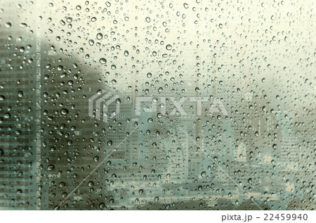 Waterdrops on a glass surface windows with closeup cityscape background Waterdrops on a glass surface windows with closeup cityscape background 22459940