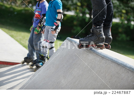Aggressive inline rollerblader standing on ramp 22467887