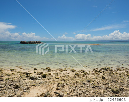 沖縄 竹富島の石がゴロゴロした星砂の浜 カイジ浜 と青い海と夏空の写真素材