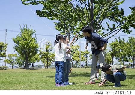 屋外の小学生と若い男性 22481211