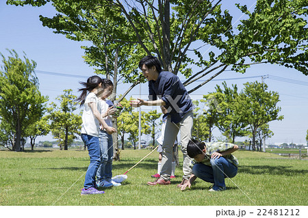 屋外の小学生と若い男性 22481212