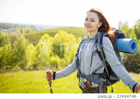 Young hiker woman with backpack standing on hill Young hiker woman with backpack standing on hill 22484746