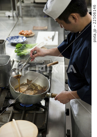 煮汁をかけながら魚を煮る調理師 煮汁をかけながら魚を煮る調理師 22506146