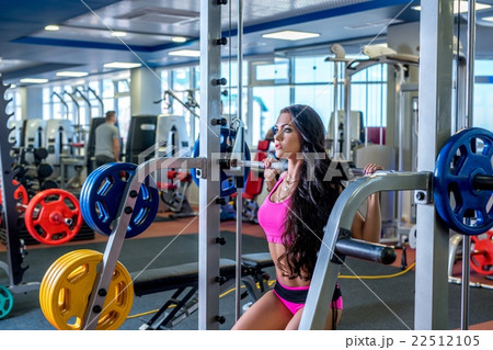 At gym. Pretty brunette training with barbell At gym. Pretty brunette training with barbell 22512105