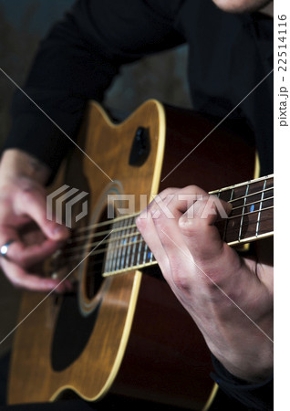 Young man playing on acoustic guitar Young man playing on acoustic guitar 22514116