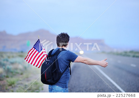 Male tourist hitchhiking along a desolate road 22527668