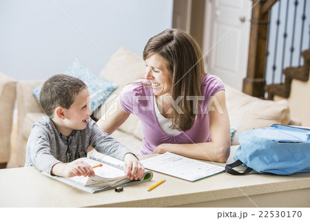 Mother helping son (6-7) doing homework 22530170
