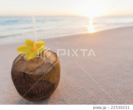 Tropical cocktail in coconut shell on sandy beach 22530231