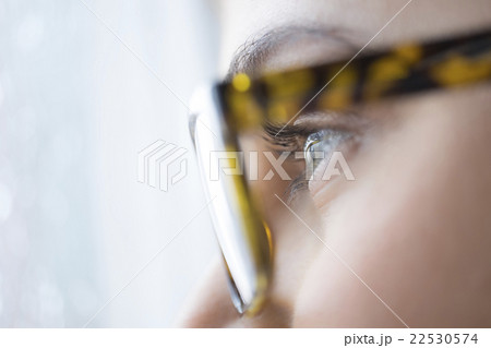Close up of young woman with blue eyes wearing glasses Close up of young woman with blue eyes wearing glasses 22530574