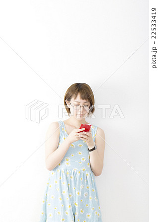 女性 スマホ カジュアル ショート ボブ 夏服 ワンピース 室内 白バック コピースペースの写真素材