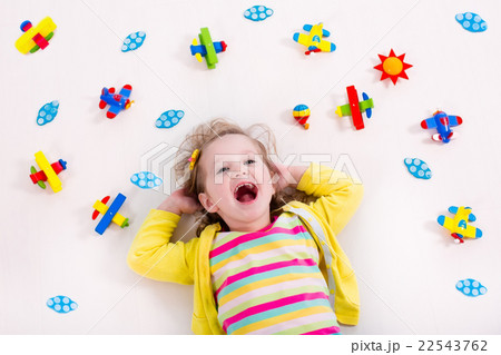 Little girl playing with wooden airplane Little girl playing with wooden airplane 22543762