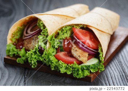 pair of fresh juicy wrap sandwiches with chicken pair of fresh juicy wrap sandwiches with chicken 22543772