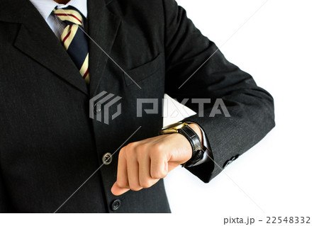 Businessman checking the time on his wrist watch Businessman checking the time on his wrist watch 22548332