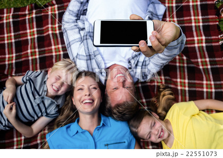 Happy family taking a selfie while lying in the park 22551073