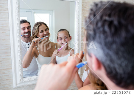 Parents and daughter brushing their teeth in the bathroo Parents and daughter brushing their teeth in the bathroo 22551078