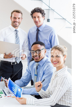 Happy business colleagues reviewing a report at desk Happy business colleagues reviewing a report at desk 22551079