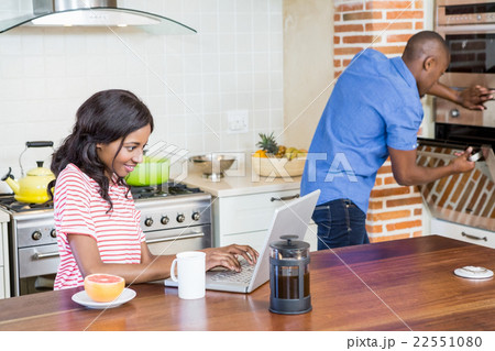 Young woman using laptop in the kitchen 22551080