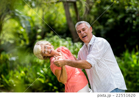 Senior couple enjoying while dancing in yard Senior couple enjoying while dancing in yard 22551620