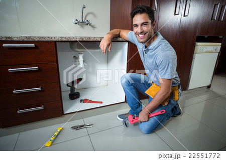 Portrait of smiling man holding pipe wrench 22551772