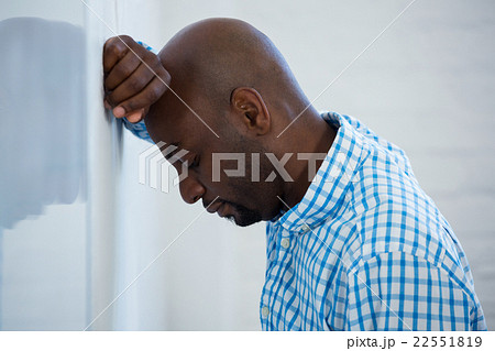 Upset man with eyes closed and hand on the forehead leaning agai Upset man with eyes closed and hand on the forehead leaning agai 22551819