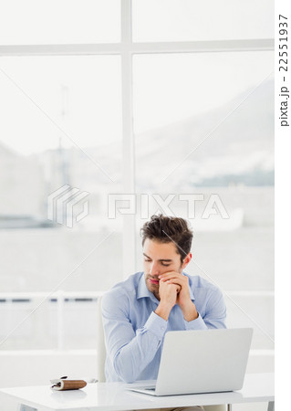 Tensed businessman sitting at table with laptop 22551937