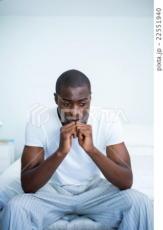 Tensed young man sitting on bed 22551940