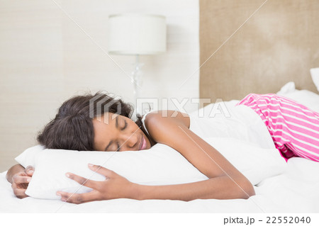 Beautiful young woman lying on bed 22552040