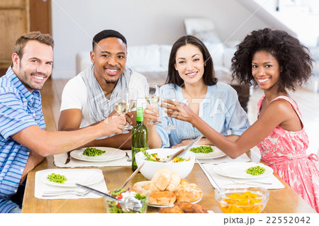 Friends toasting wine glasses while having a meal 22552042