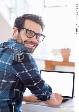 Happy young man using laptop at home Happy young man using laptop at home 22552314