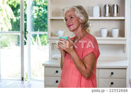 Smiling senior woman having coffee in kitchen 22552686