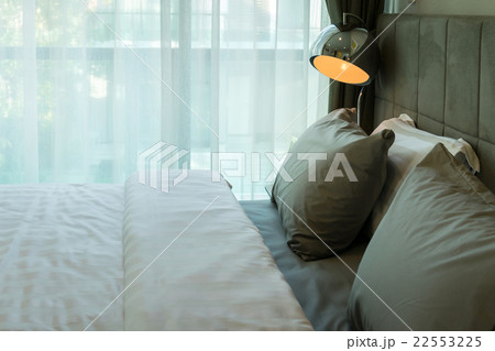 metal desk lamp and grey pillow on bed metal desk lamp and grey pillow on bed 22553225