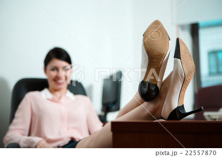 Relaxed business woman sitting in a chair with 22557870