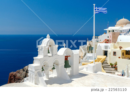 White bell tower and Greek flag in Oia. 22563110