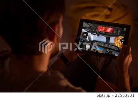 Guy holding a tablet and playing videogame 22563531