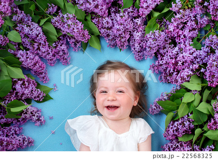 pretty little girl lying on blue background with 22568325