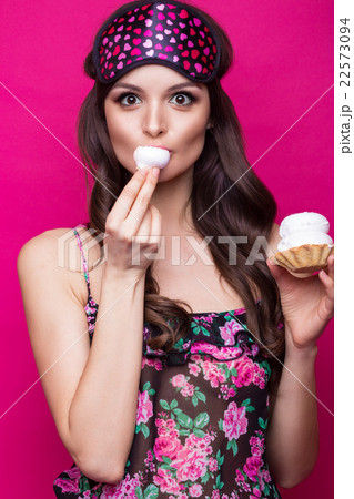 young woman in sleeping mask and pajamas, sweets. young woman in sleeping mask and pajamas, sweets. 22573094