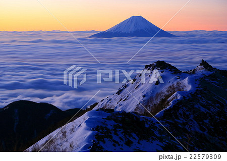 南アルプス・観音岳から雲海に浮かぶ黎明の富士山と薬師岳の岩峰 22579309