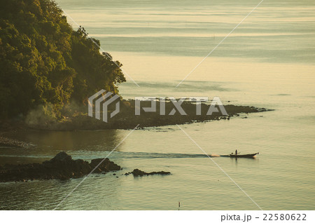 Silhouette small boat off the coast in sunrise 22580622